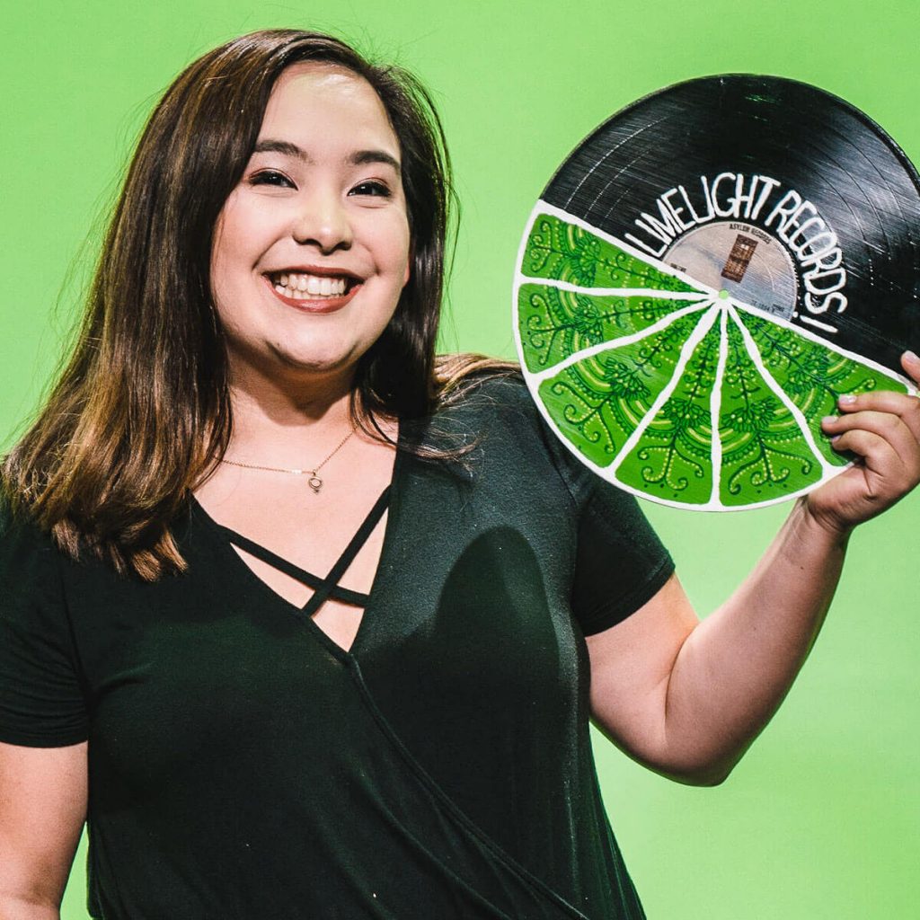 Natalie Sakoi holding up a record that reads "Limelight Records".