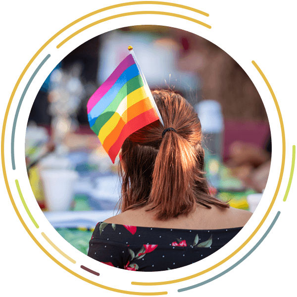 View of the back of a student's head with a pride flag stuck in their hair.