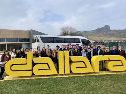 Group standing behind Dallara sign
