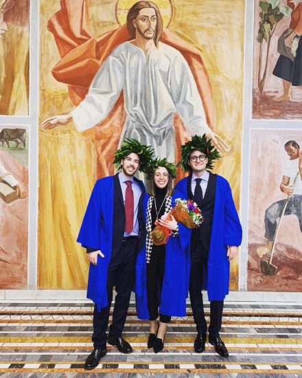 Three students standing in their graduation gowns
