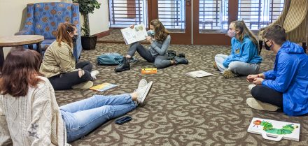 Kaitlin Cirillo '24 reads a children's book to her Elon College Fellows classmates before they analyze its themes.