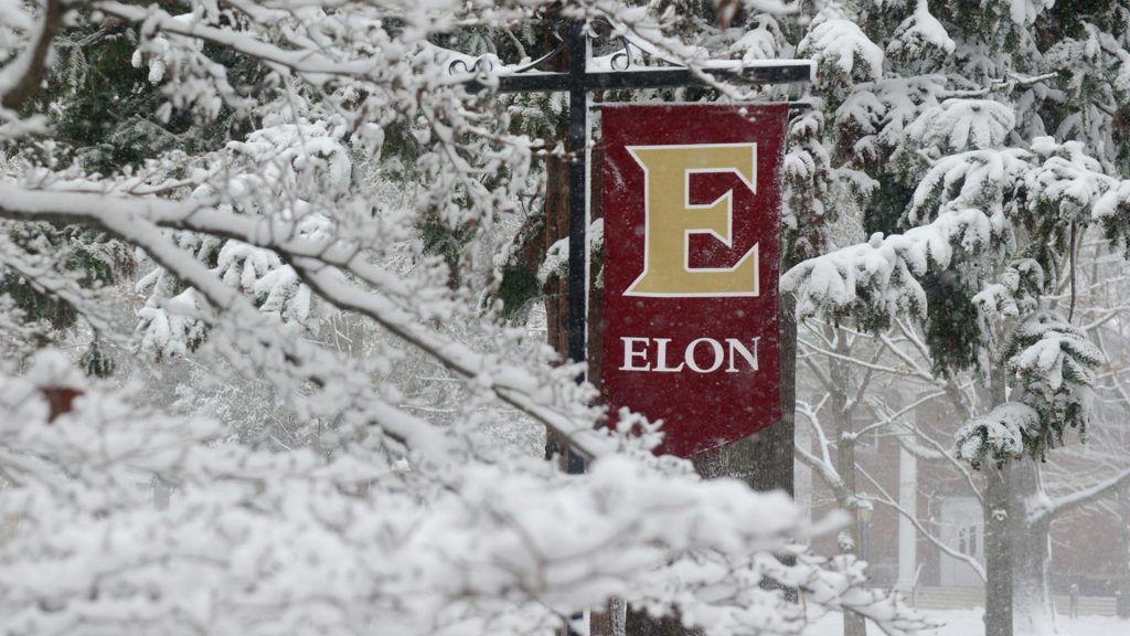 Elon University banner covered in snow.